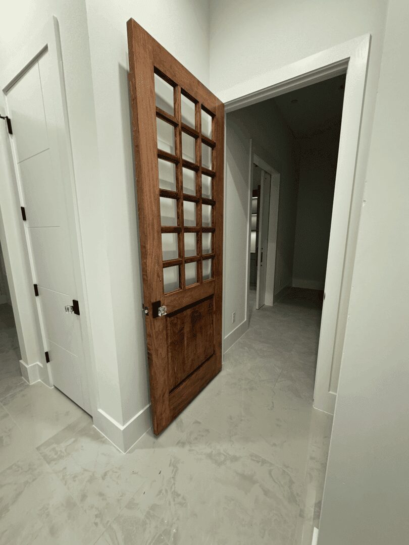 Wooden door partially open in hallway.