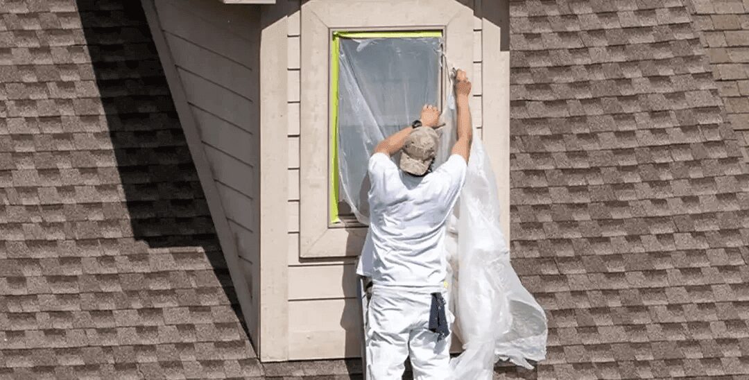 Man working on window of house exterior.