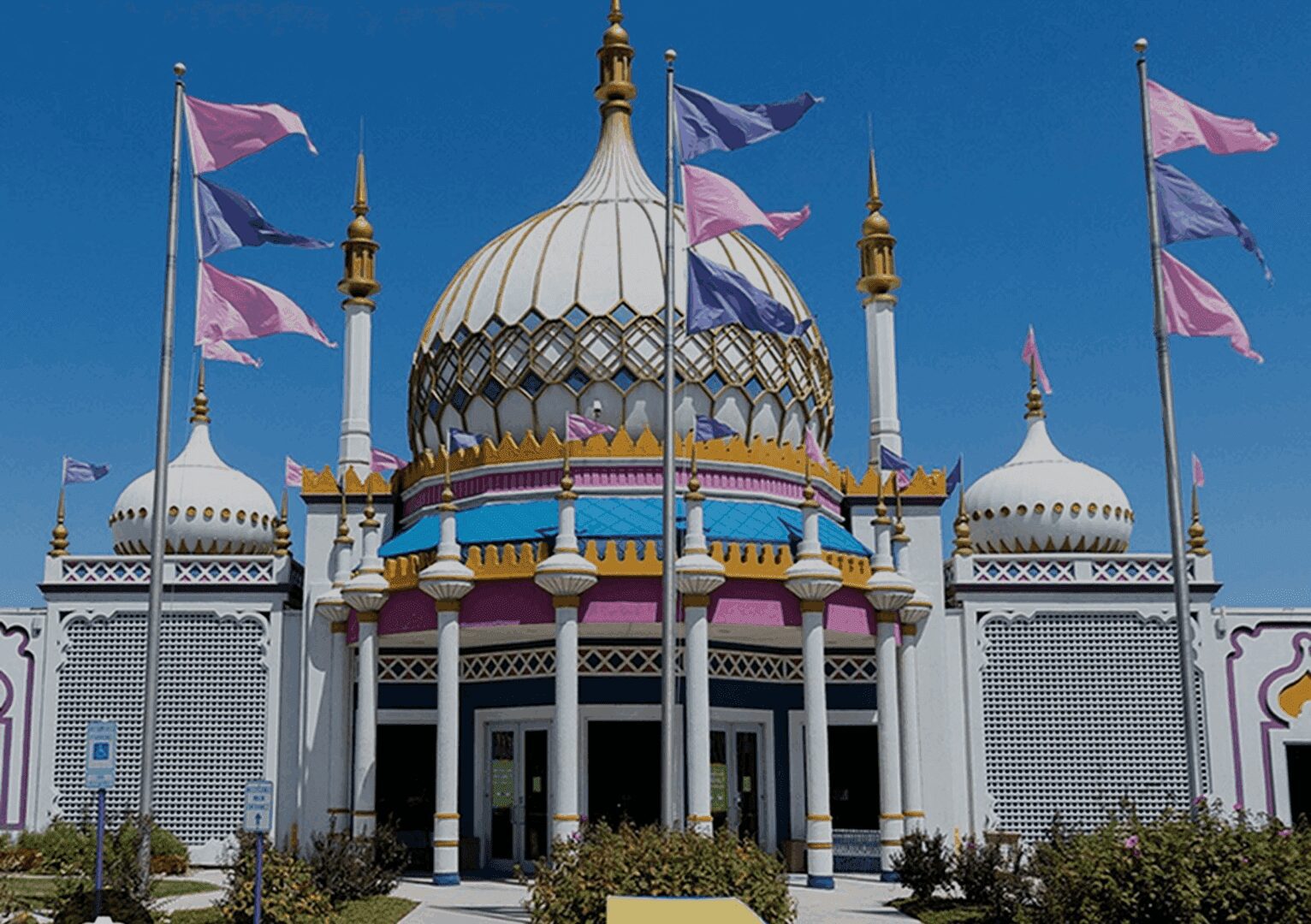 Colorful building with domes and flags outside.